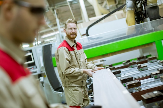 Twee jonge mannen die in de meubelfabriek werken