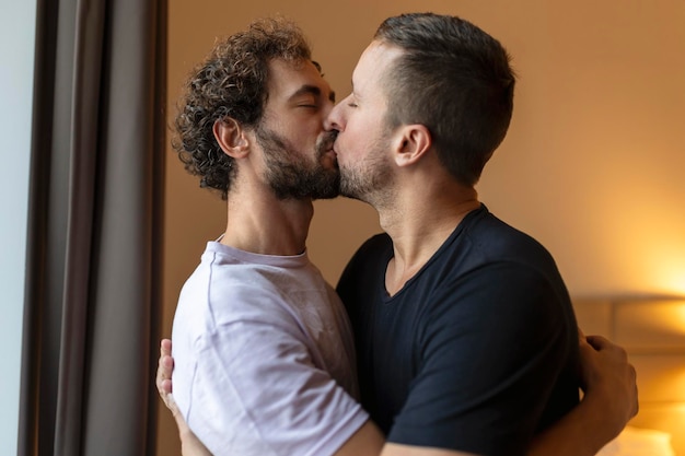 Twee jonge mannen lgbtq homo paar dating verliefd knuffelen genieten van intiem teder sensueel moment samen zoenen met gesloten ogen