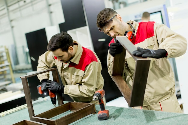 Twee jonge mannen werken in een fabriek voor de productie van meubels