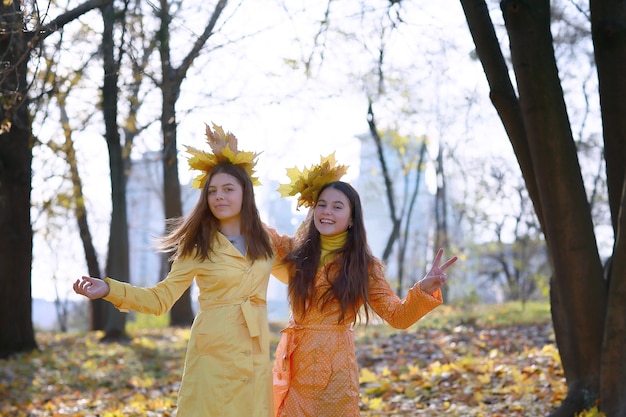 Twee jonge meisjes in de herfstpark tijdens de herfsttijd