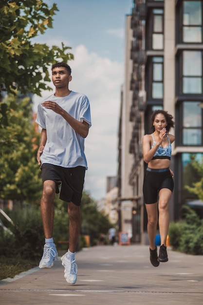 Twee jonge mensen in sportkleding die samen rennen