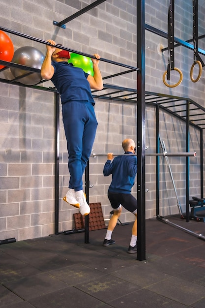 Twee jonge mensen trainen in de sportschool in de pandemie van het coronavirus een nieuw normaal met beschermend gezichtsmasker