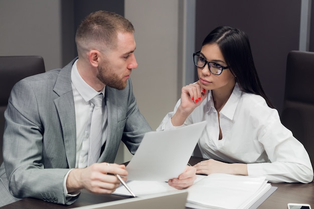 Twee jonge mensen uit het bedrijfsleven bespreken werk tijdens een bedrijfspresentatie in vergaderruimte