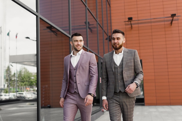 Twee jonge moderne zakenman wandelen in de stad