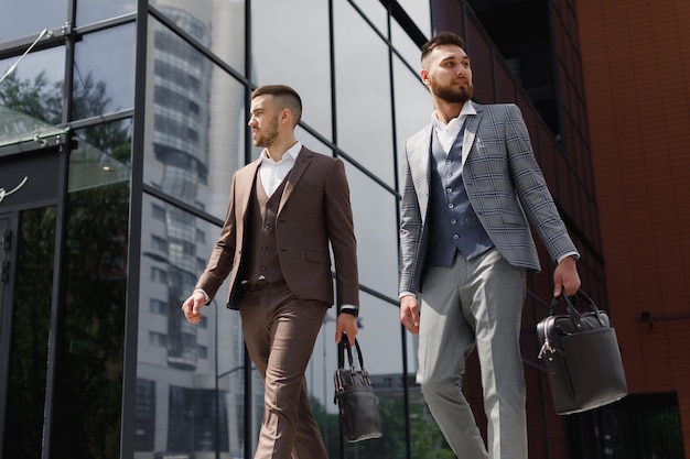 Twee jonge moderne zakenman wandelen in de stad