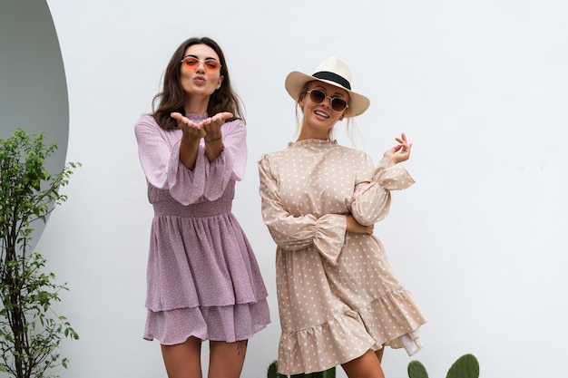Twee jonge mooie lachende hipster vrouw in trendy zomer sundress Sexy zorgeloze vrouwen die zich voordeed op de straat achtergrond Positieve modellen plezier