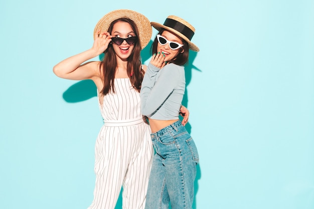 Twee jonge mooie lachende hipster-vrouwen in trendy zomers wit t-shirt en jeanskleding