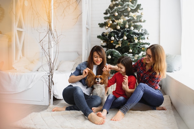 Twee jonge mooie vrouwen en een klein meisje terwijl het vieren van Kerstmis thuis