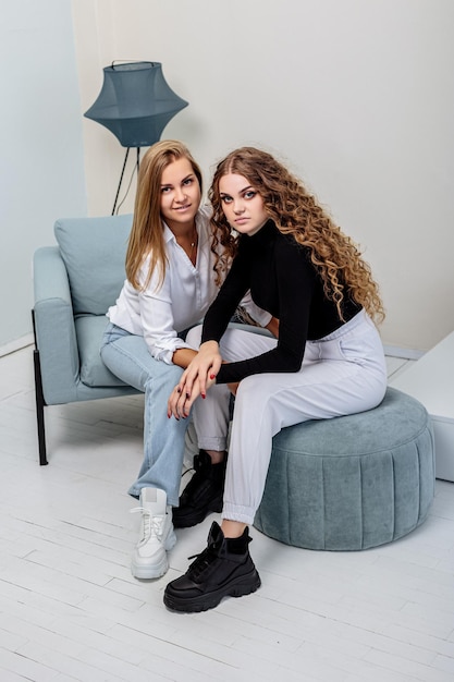 Twee jonge mooie vrouwen in broeken en een trui, in leren laarzen aan hun voeten. nieuwe collectie dameslaarzen