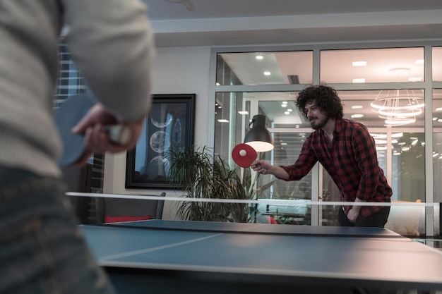 Twee jonge start-up zakenman die pingpongtennis speelt bij moderne creatieve kantoorruimte mensen grou