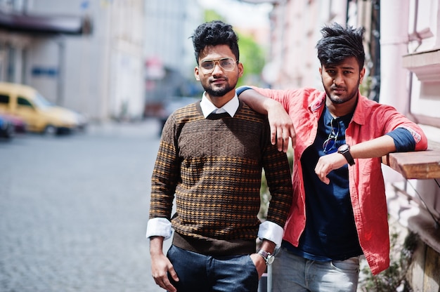 Twee jonge stijlvolle Indiase man gebakken model poseren in straat.