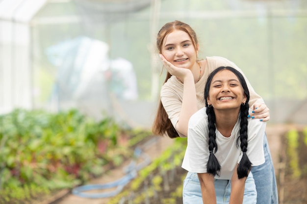 Twee jonge tienermeisjes blij lachend samen vriend mix race in parktuin