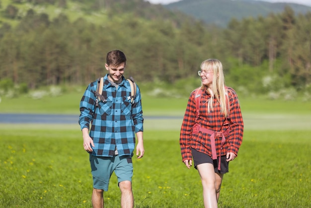 Twee jonge volwassenen, een man en een vrouw, genieten samen tijdens een wandeling.