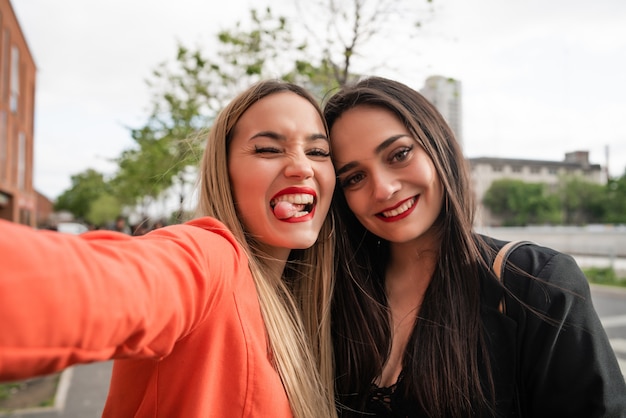 Twee jonge vrienden die een selfie in openlucht nemen