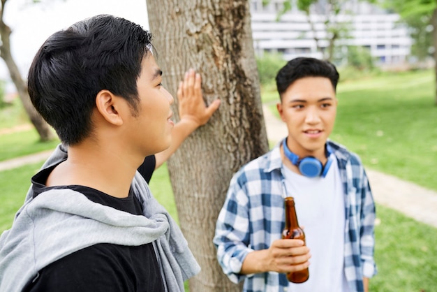 Twee jonge vrienden die met elkaar praten en bier drinken terwijl ze tijd doorbrengen in de frisse lucht