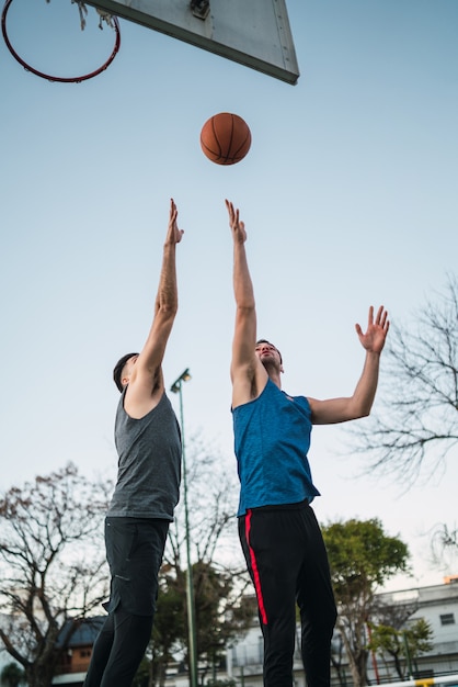 Twee jonge vrienden spelen basketbal