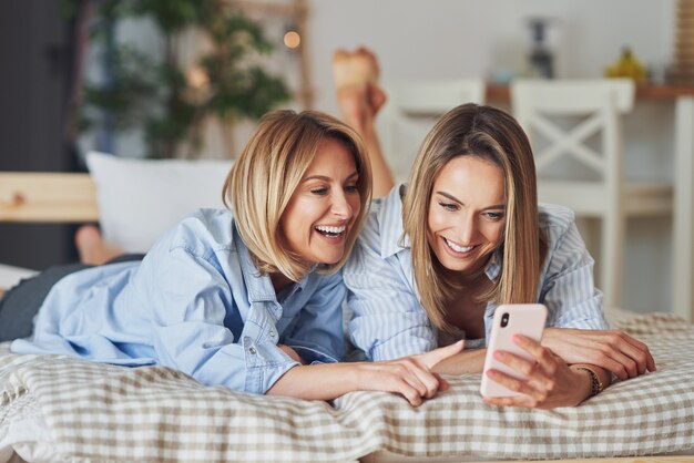 Twee jonge vriendinnen op het bed selfie te nemen. Hoge kwaliteit foto