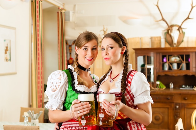 Twee jonge vrouwen in traditionele Beierse klederdracht in restaurant of pub