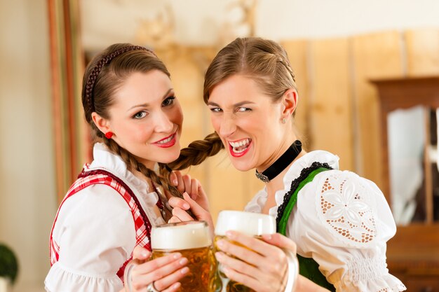 Twee jonge vrouwen in traditionele Beierse klederdracht in restaurant of pub