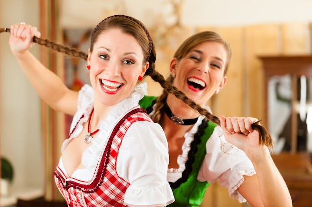 Twee jonge vrouwen in traditionele Beierse klederdracht in restaurant of pub