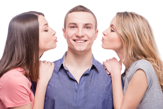 Twee jonge vrouwen kussen aan de man.