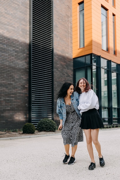 Twee jonge vrouwen lopen lachend over straat