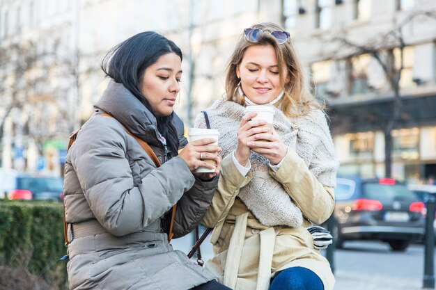 Twee jonge vrouwen met warme drank