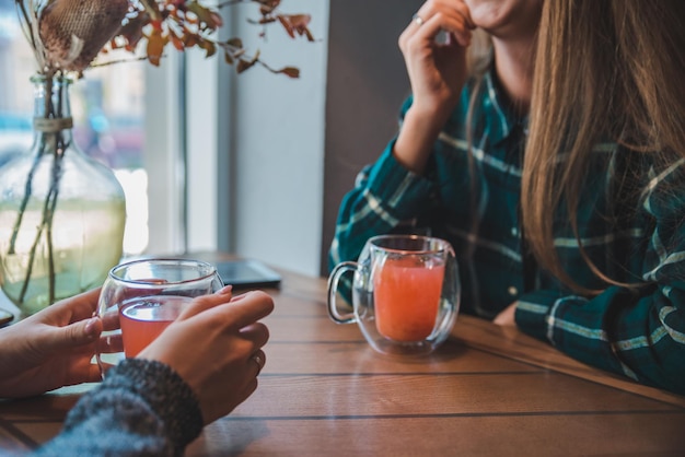 Twee jonge vrouwen praten in café en drinken warming-up thee concept