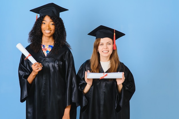 Twee jonge vrouwen vieren hun afstuderen met diploma's