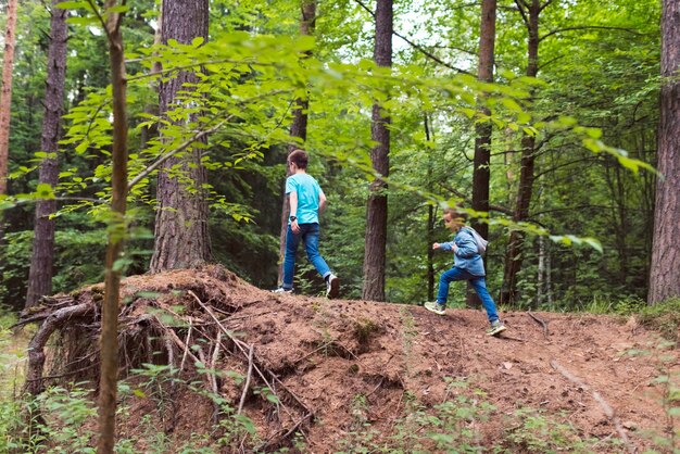 twee jongens rennen in het bos