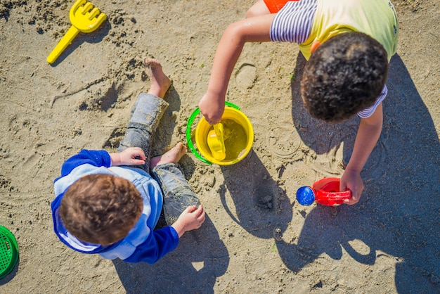 Twee jongens spelen over zand met strand speelgoed