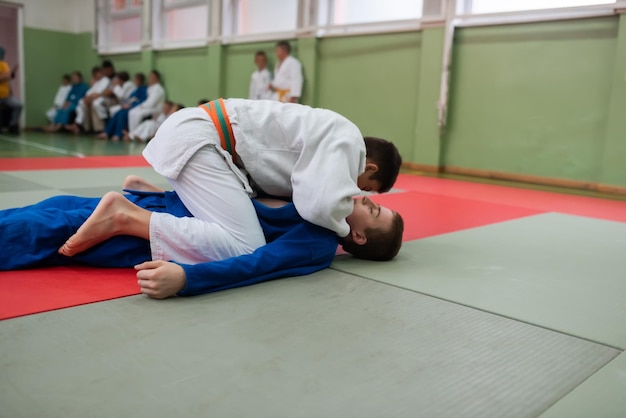 Twee judovechters die technische vaardigheid tonen tijdens het beoefenen van vechtsporten in een vechtclub De twee fitte mannen in uniform vechten karate training kunsten atleet competitie concept Selectieve aandacht