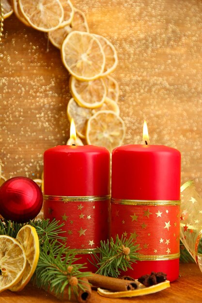 Twee kaarsen en kerstversiering, op gouden achtergrond