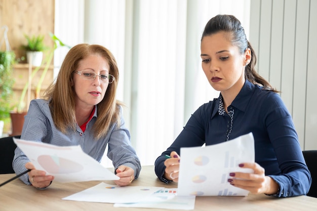 Twee kaukasusvrouwen zitten met een paar lakens vooraan. nieuwe project stagiair