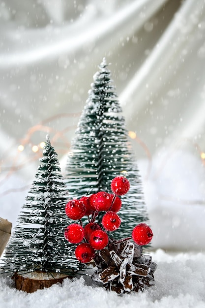 Twee kerstbomen op champagne gekleurde zijden achtergrond en witte sneeuw trendy