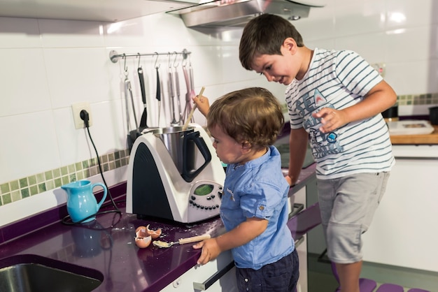 Twee kinderen bereiden pannenkoeken met een keukenrobot.