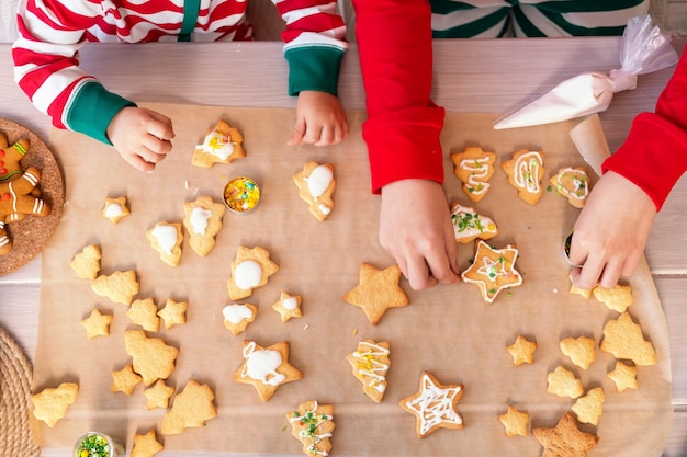 twee kinderen jongen en meisje in pyjama feestelijke peperkoek koken in de keuken. bovenaanzicht