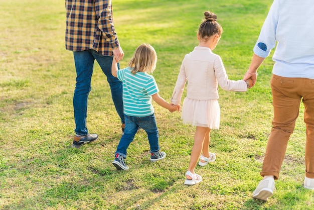 Twee kinderen lopen hand in hand met hun vaders