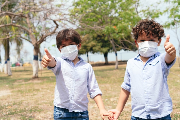 Twee kinderen met beschermende maskers in het park