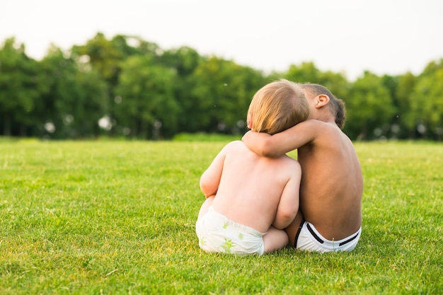 Twee kinderen op de avondopen plek spelen en knuffelen.