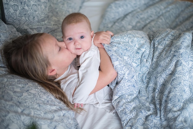 twee kinderen spelen in bed