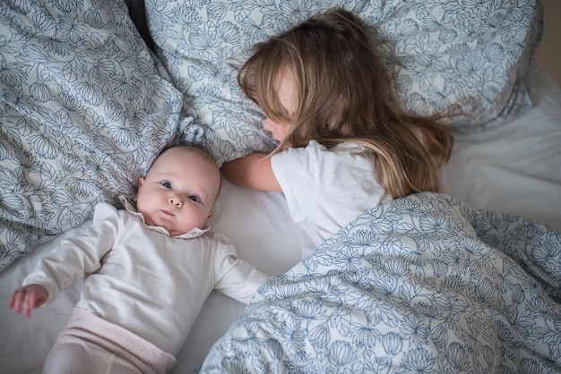 twee kinderen spelen in bed