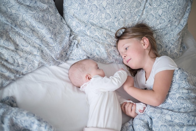 twee kinderen spelen in bed