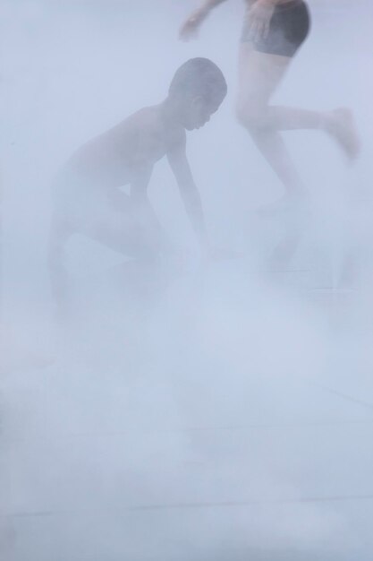 Twee kinderen spelen in de mist.