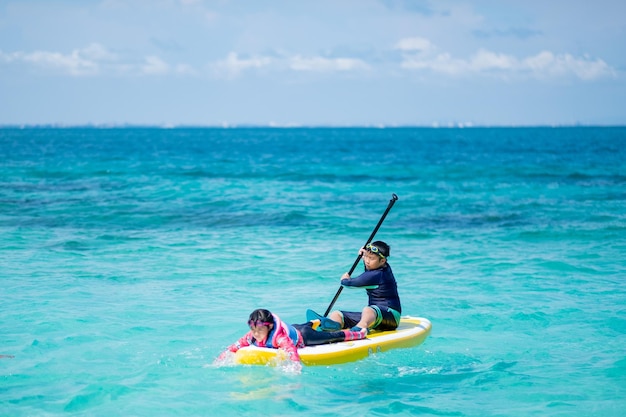 Twee kinderen surfen in de zee