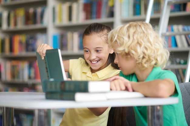 Twee klasgenoten die hun huiswerk maken aan de bibliotheekbalie