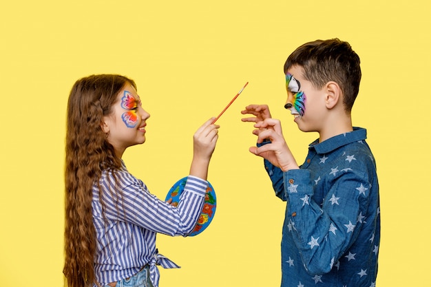 Twee kleine beste vrienden of zus met broer aquagrim doen met gouache en verjaardag vieren