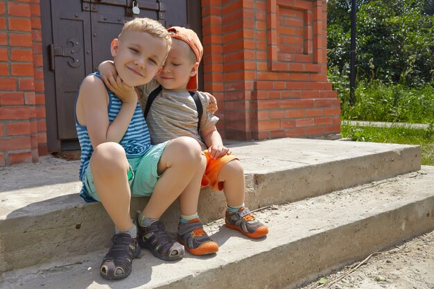 Twee kleine broertjes zitten in het zomerpark