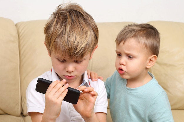 Twee kleine jongen kijken naar de smartphone