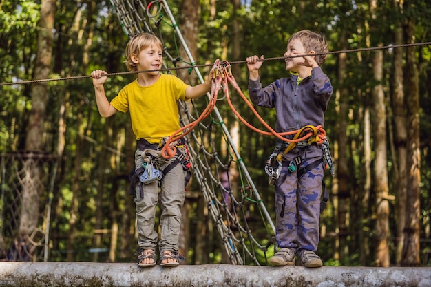 Twee kleine jongens in een touwpark Actieve fysieke recreatie van het kind in de frisse lucht in het park Training voor kinderen